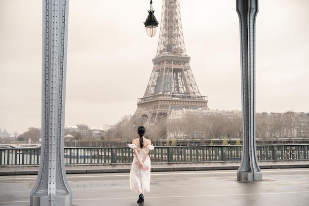 Woman portrait under Bir Hakeim bridge with Eiffel tower Paris France