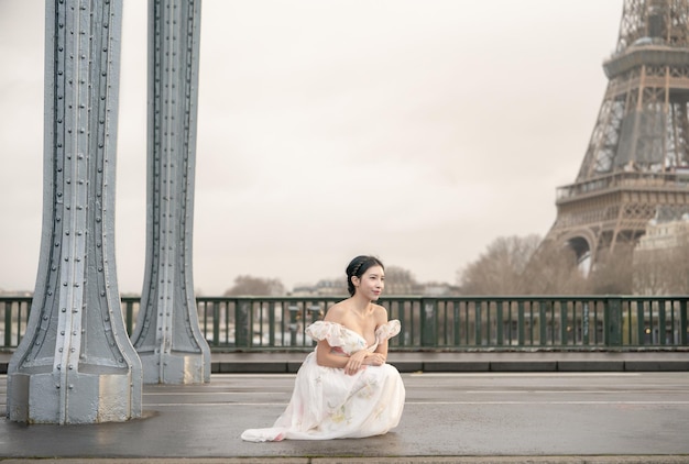 Woman portrait under Bir Hakeim bridge with Eiffel tower Paris France