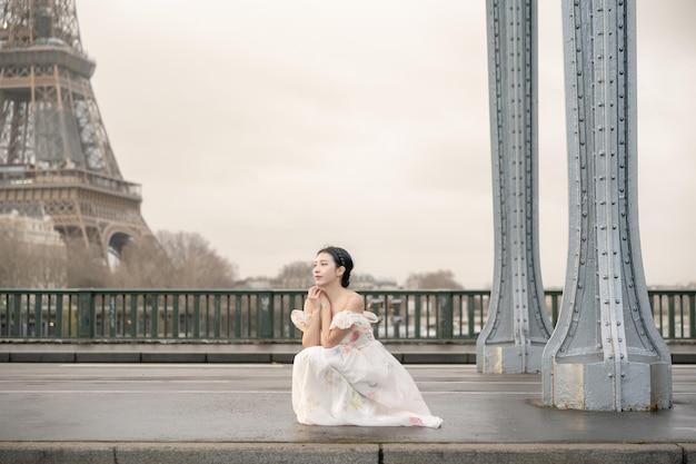 Woman portrait under Bir Hakeim bridge with Eiffel tower Paris France