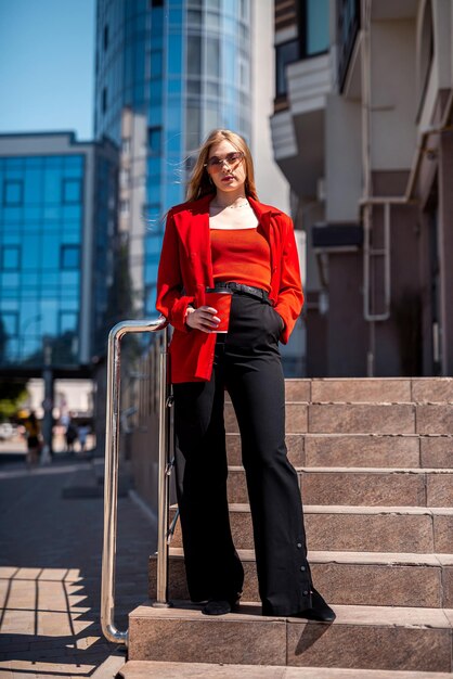 Woman portrait of businesswoman in a suit standing near an office building with her