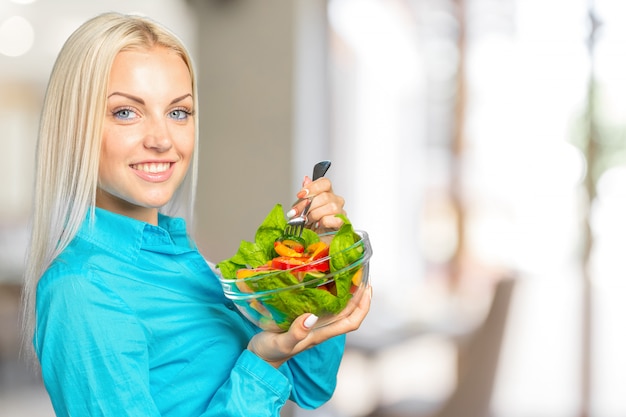 Woman portrait eating green salad with tomatoes 