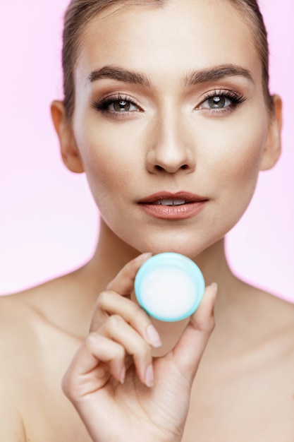 woman portrait holding a little cream