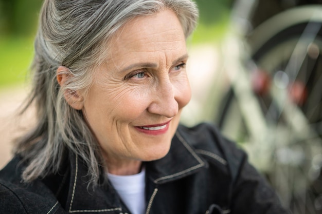 Photo a woman. portrait of a mature woman smiling and looking aside