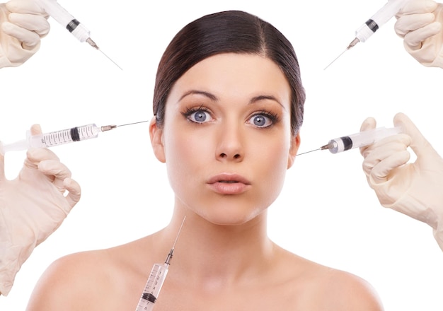 Woman portrait and syringe for plastic surgery in shock in studio injection and chemical by white background Girl patient surgeon and wow for needle with change transformation or beauty results