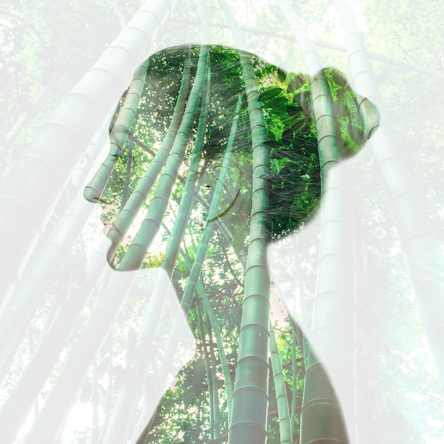 Ritratto di donna con doppia esposizione e con alberi di bambù verdi da vicino