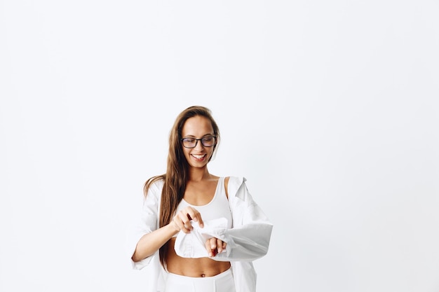 Woman portrait with tanned skin and long natural flowing hair posing on a white background wearing eyeglasses