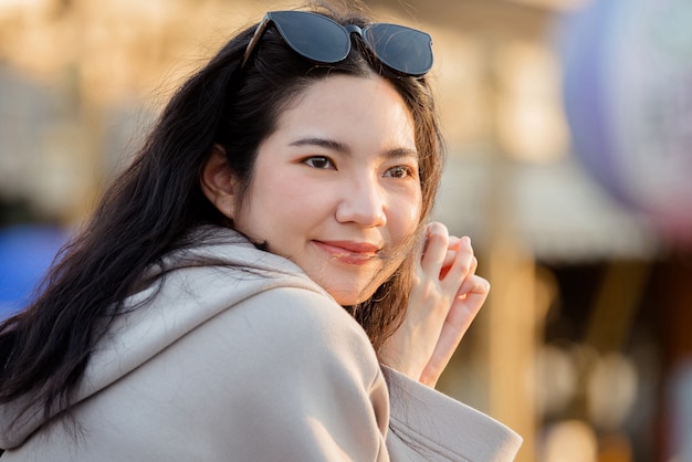 写真 夕方に買い物をする女性の肖像画の若いタイの女性、川沿いの夕日を歩く女性のライフスタイル、率直な肖像画の女性バンコク、タイ、アジア。