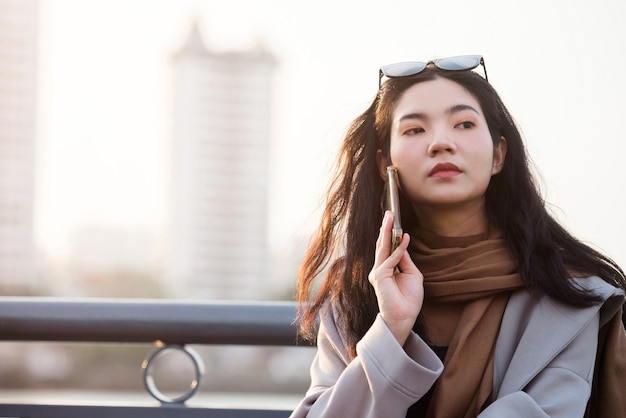 夕方に買い物をする女性の肖像画の若いタイの女性、川沿いの夕日を歩く女性のライフスタイル、率直な肖像画の女性バンコク、タイ、アジア。