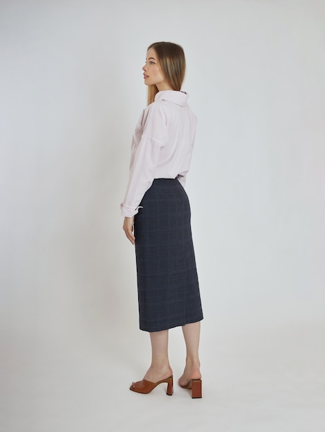 Woman poses with blue skirt and white blouse