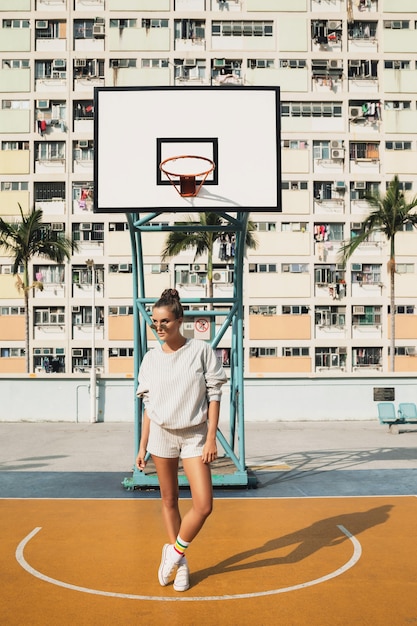 Foto donna in posa sul campo da basket nella città di hong kong