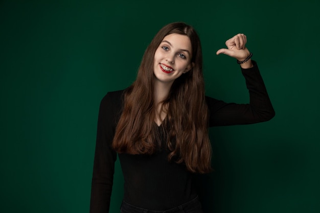 Woman posing in front of green background