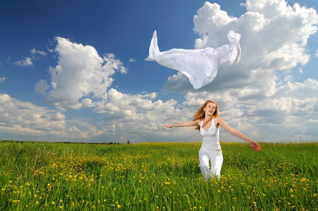 Woman posing in a green field with airiness silk