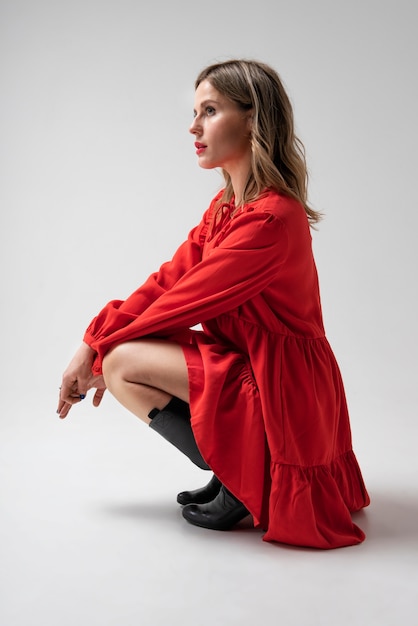 Фото Женщина позирует в красном платье в полный рост