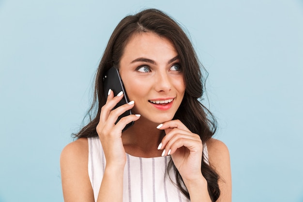 Woman posing isolated wall talking by mobile phone.