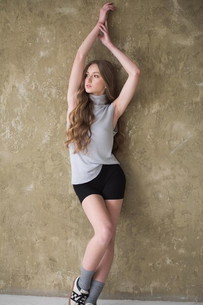 Photo woman posing near wall