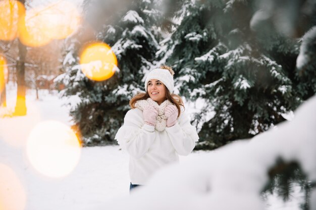 Woman posing in park with Christmas lights. Winter holidays concept.