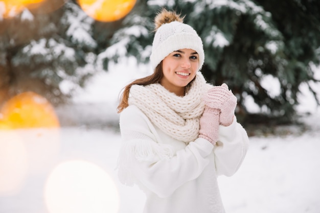 Woman posing in park with Christmas lights. Winter holidays concept.