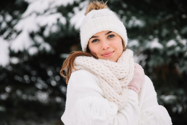 Woman posing in park with Christmas lights. Winter holidays concept.