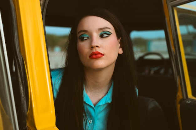 Woman posing together in retro style with car