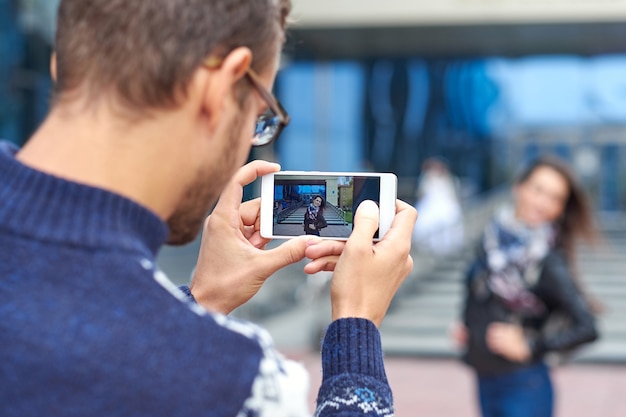 Woman posing for vacation photo in urban city tour. Couple of tourists making photo