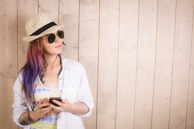 Woman posing while holding mobile phone