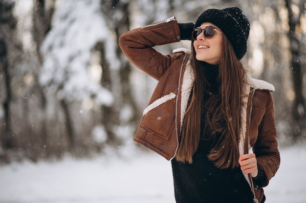 Donna che posa nella foresta di inverno