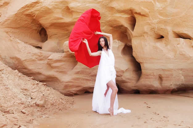 Фото Женщина позирует с красной тканью на открытом воздухе