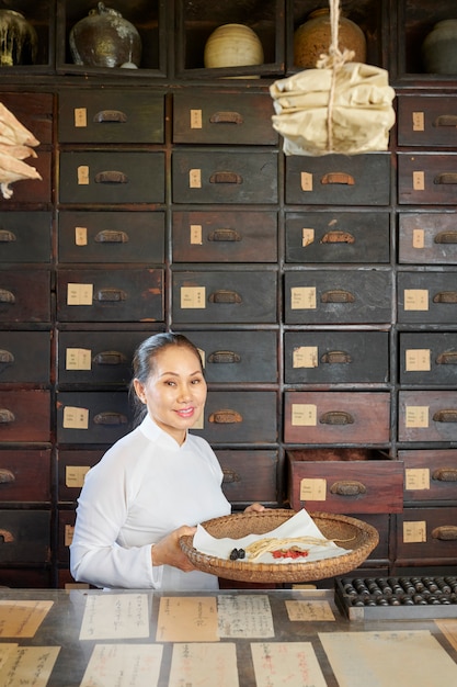 Woman posing with basket of dry roots and berries