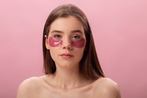 Photo woman posing with eye patches front view