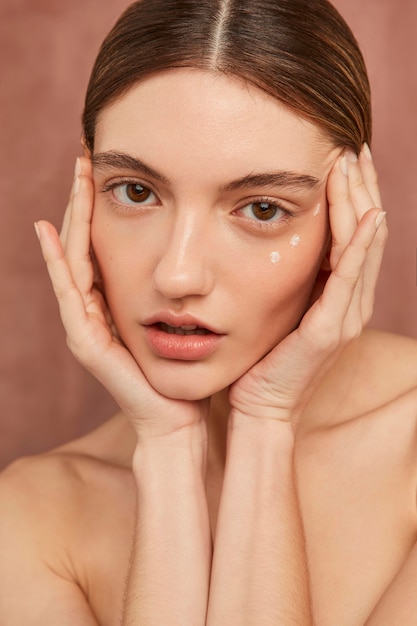 Woman posing with face cream close up