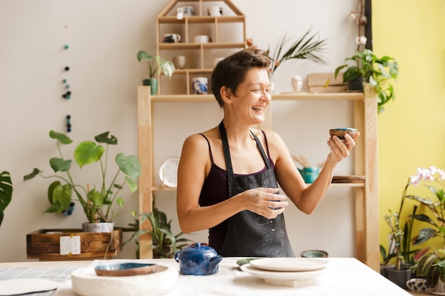 Woman potter drinking tea at the workshop