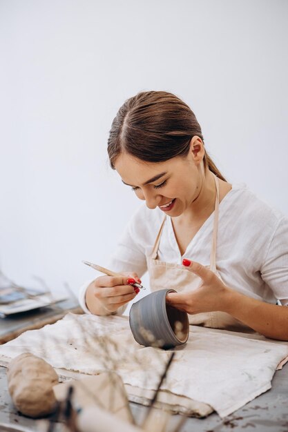 Foto donna al negozio di ceramiche che decora la ciotola di ceramica