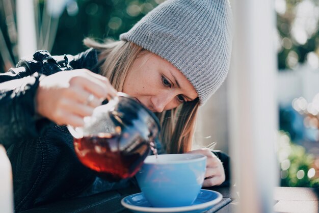 Woman pouring coffee in cup