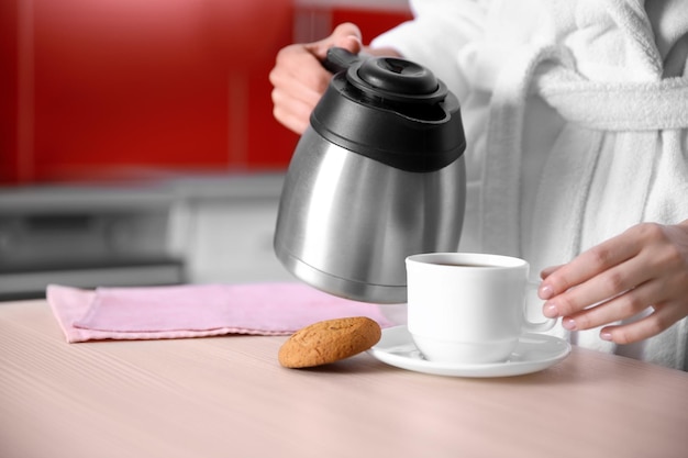 Woman pouring coffee in kitchen