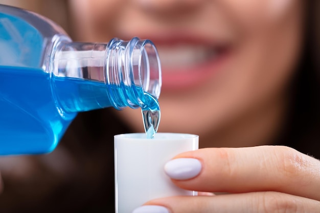 Woman Pouring Mouthwash Into Cap