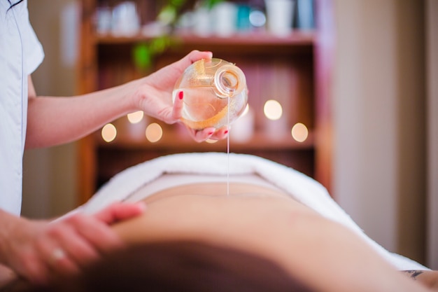 Photo woman pouring oil on client