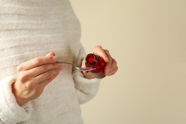 Woman pouring syrup in spoon, space for text