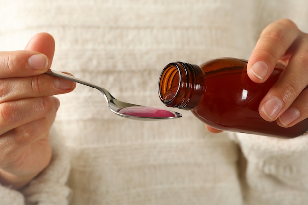 Woman pouring syrup in spoon