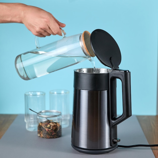 Photo woman pouring water into a kettle to make tea