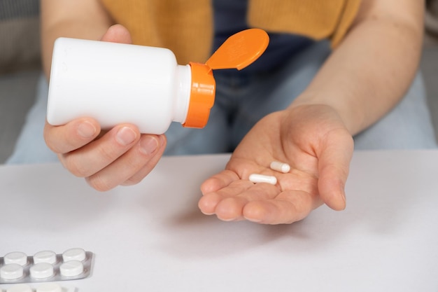 A woman pours capsules out of a jar Medicines and medicine