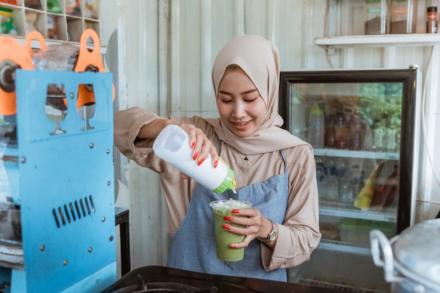 A woman pours a milk in the drink