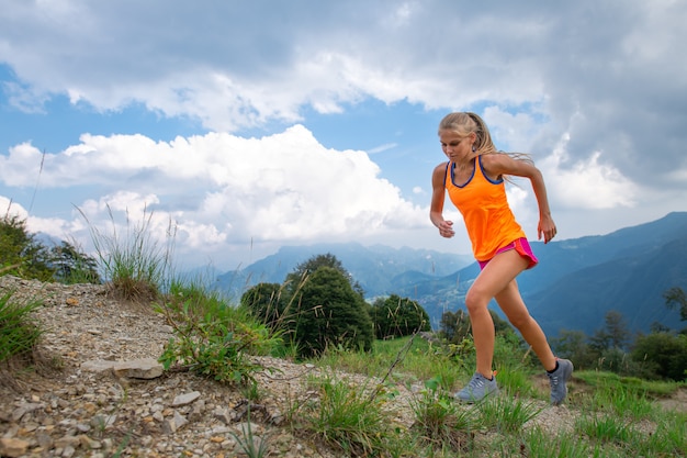 A woman practice running on trail in the mountains