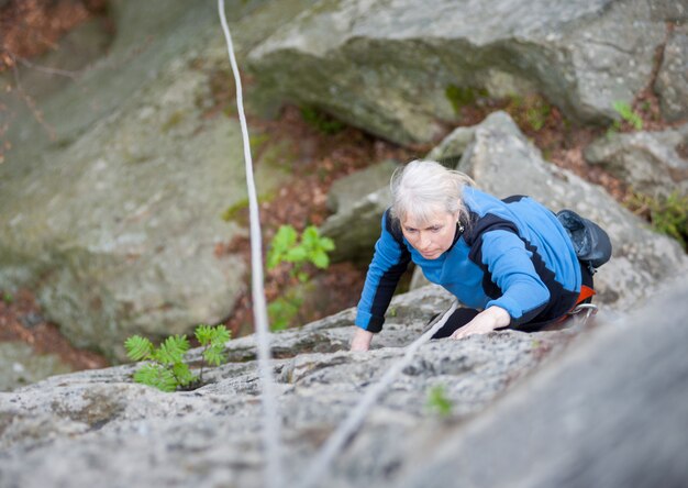 Woman practices in climbing at the rock in the mountains