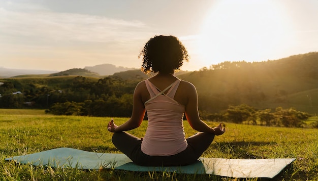 woman practices yoga and meditates in the lotus position on the field