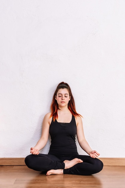 Woman practices yoga and meditates in the lotus position