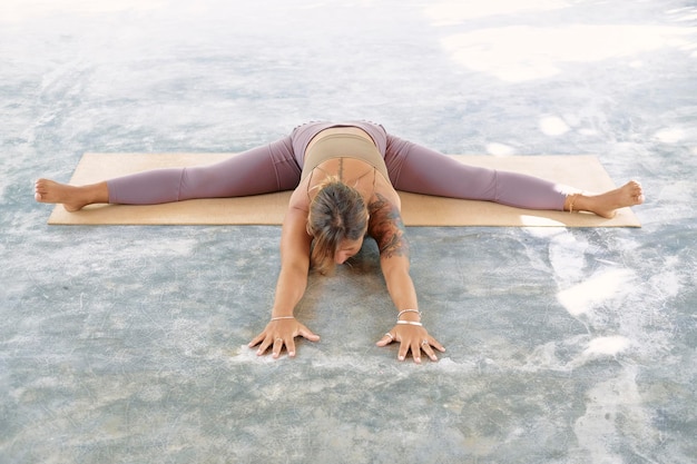 Photo woman practicing advanced yoga on organic mat series of yoga poses tropical background