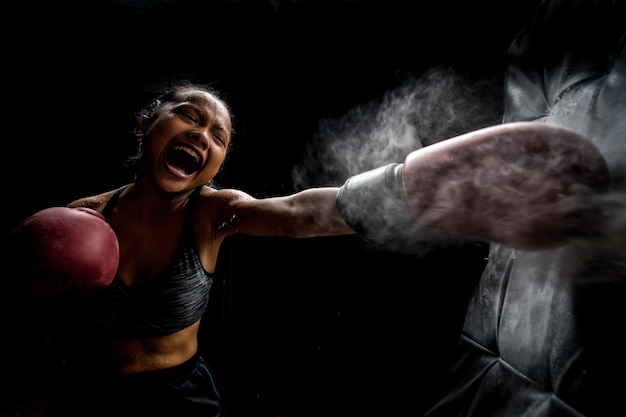 Photo woman practicing boxing against black background