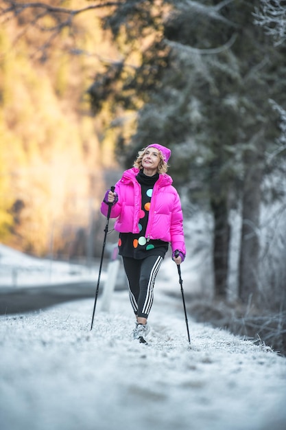 Woman practicing Nordic walking on frozen road