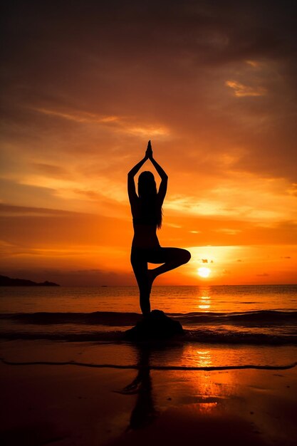 A woman practicing yoga on the beach at sunset