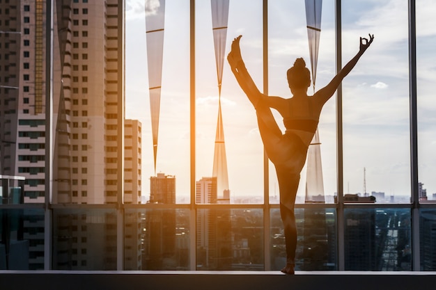 Photo woman practicing yoga on city view